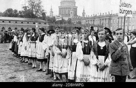 Der Verein für das Deutschtum im Ausland e.V. feiert in Potsdam sein 50-jähriges Bestehen. Am Nachmittag treffen sich die Vertreter aller deutschen Verbände aus dem Ausland zu einem großen Fest. Hier ist eine Gruppe von Mädchen aus Siebenbürgen in Nationalkostüm gekleidet. Hinter ihnen eine Gruppe aus der Saar-Region. Im Hintergrund die Kuppel der St. Nikolaus-Kirche. Stockfoto