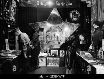 "In der Mitte ist ein kommunistischer Stern vom Friedhof Lichtenberg. ''Rechts ist Sonja, die Neue Deutsche mit einem original weiblichen Kepi der russischen Soldatinnen''(Originaltext von 1935). Im Revolutionsmuseum in der Franzoesischen Straße in Berlin diffamiert der nationalsozialistische Ausstellungsmacher seine politischen Gegner." Stockfoto