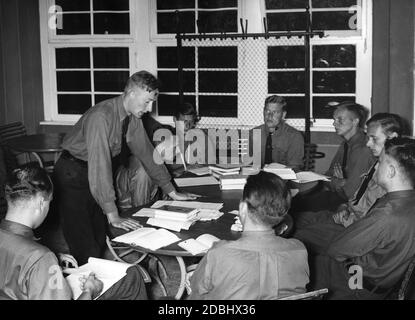 "Die Teilnehmer eines Trainingslagers der NSDStB in der NSV-Gauschule Wilhelmshagen diskutieren in einer Studiengruppe das Thema "die Partei als Willensträger der Nation" bei einem Rundgang durch die Berliner Presse." Stockfoto