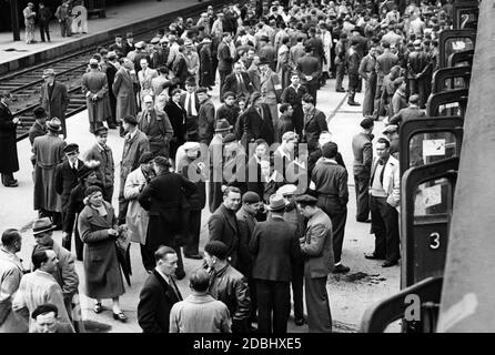 "Ehemalige französische Kriegsgefangene kehren als Arbeiter ins Deutsche Reich zurück. Auf dem Bild stehen zahlreiche Menschen kurz vor der Abfahrt des Zuges auf einer Plattform. Während des Vichy-Regimes organisierte der "Service du travail obligatoire" die Rekrutierung französischer Fachkräfte für die deutsche Kriegswirtschaft." Stockfoto