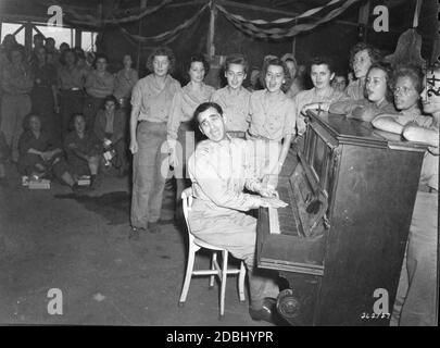 Irving Berlin, berühmter Broadway-Songwriter auf Tour durch den Südwestpazifik, spielt eine seiner Melodien in der Women's Army Corps Mess Hall am Hauptquartier der US Army Forces Far East, Hollandia, Niederländisch-Neuguinea, 12/24/1944. (Foto von US Army Signal Corps/RBM Vintage Images) Stockfoto