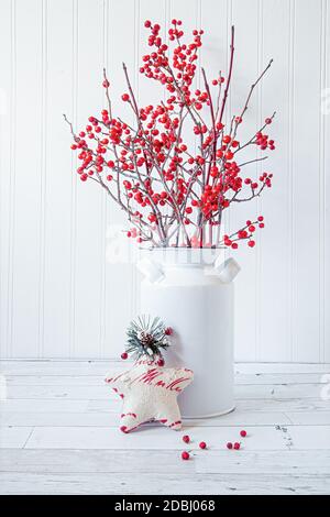 Winterberries, ein einheimischer nordamerikanischer Strauch, in einer kleinen Dose Milchdose angeordnet. Stockfoto