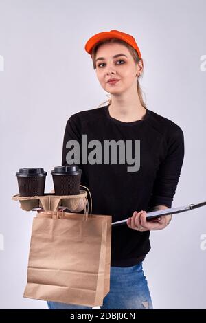 Europäische Kurierin mit Kaffee und Papierpaket. Stockfoto