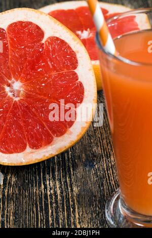 Frischer Grapefruitsaft aus saftigen roten Grapefruits auf natürliche Weise, neben frischen Früchten Stockfoto