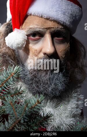 Make-up weihnachtsmann piepst aus dem Baum. halloween-Konzept weihnachten Zombie santa tot Weihnachtsmann hält Skier in den Händen und Geschenke Stockfoto