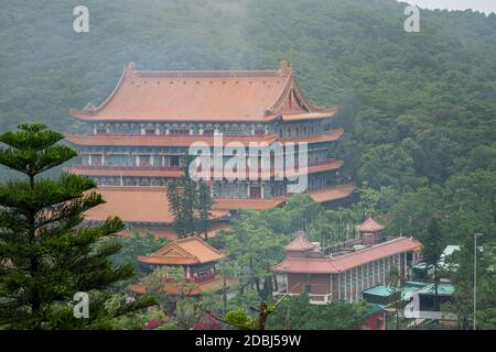 Blick auf das Kloster Po Lin im Nebel im Dorf Ngong Ping auf der Insel Lantau, Hongkong Stockfoto