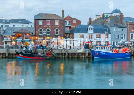 Blick auf Boote im Alten Hafen und Kaimandhäuser in der Abenddämmerung, Weymouth, Dorset, England, Großbritannien, Europa Stockfoto