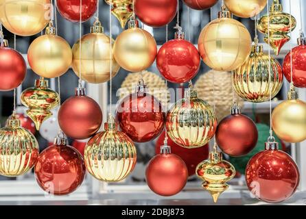 Rote und gelbe Glas Weihnachtskugeln hängen an Fäden. Stockfoto