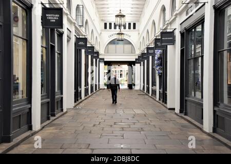 Ein Mann mit Gesichtsmaske geht während der zweiten nationalen Sperre in England an geschlossenen Geschäften im Covent Garden Market, London, vorbei. Stockfoto