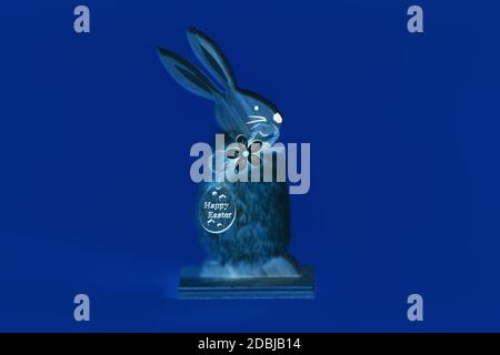 Osterhase aus Holz, auf einem isolierten gelben Hintergrund. Das Konzept von Ostern, der Osterhase im Neonstil Stockfoto