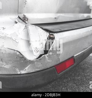 Beschädigtes Fahrzeug. Verkehrsunfall. Rückseite des grauen Autos erhalten durch Unfall auf der Straße beschädigt. Stoßfänger des Fahrzeugs durch Autounfall beschädigt. Foto im Retro-Stil. Stockfoto