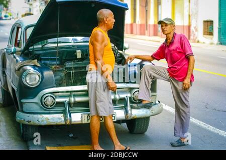 15. Juli 2019 - Havanna Kuba. Altes retro-beschädigtes Auto in Havanna mit zwei Personen Stockfoto
