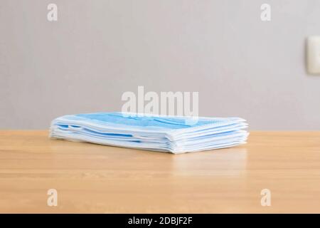 Eine Packung medizinischer Masken auf dem Tisch. Persönliche Schutzausrüstung. Stockfoto