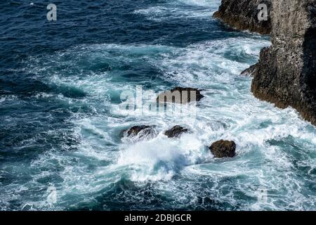 Wellen, die auf Felsen in Les Aiguilles de Port Coton, auf der Insel Belle Ile, Bretagne, Frankreich, schwappen. Berühmt gemacht in Gemälden von Claude Monet. Stockfoto