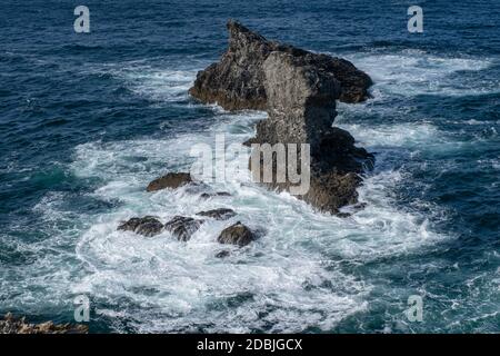 Wellen, die auf Felsen in Les Aiguilles de Port Coton, auf der Insel Belle Ile, Bretagne, Frankreich, schwappen. Berühmt gemacht in Gemälden von Claude Monet. Stockfoto