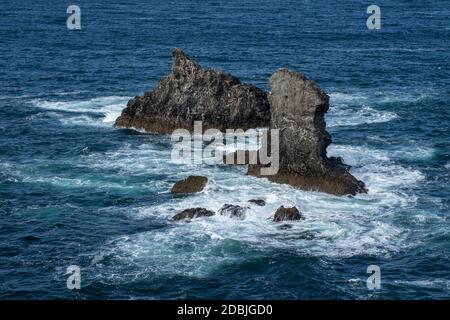Wellen, die auf Felsen in Les Aiguilles de Port Coton, auf der Insel Belle Ile, Bretagne, Frankreich, schwappen. Berühmt gemacht in Gemälden von Claude Monet. Stockfoto