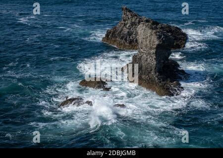 Wellen, die auf Felsen in Les Aiguilles de Port Coton, auf der Insel Belle Ile, Bretagne, Frankreich, schwappen. Berühmt gemacht in Gemälden von Claude Monet. Stockfoto