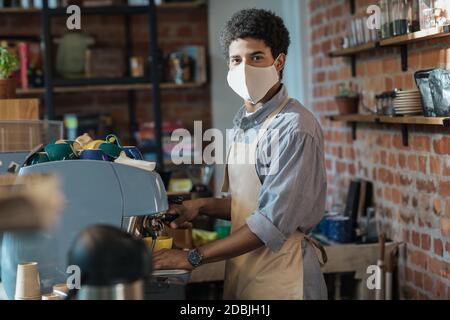 Soziale Distanz, neue Normalität, Kaffee zum Annehmen bestellen und moderne Barista-Arbeit Stockfoto