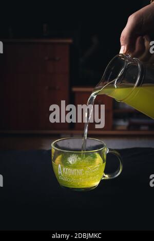 Gießt heißen grünen Tee in einen Becher Stockfoto