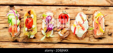 Set aus leckeren italienischen Bruschettas oder Kanape mit Gemüse.verschiedene Bruschetta auf einem Holztisch sortiert Stockfoto