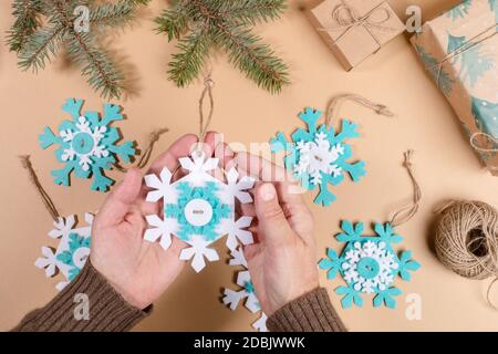 DIY-Anleitung. Schritt-für-Schritt-Anleitung. Machen Weihnachten Spielzeug Schneeflocke aus Filz. Schritt 7 - Binden Sie Fäden auf Schneeflocken in Knoten. Draufsicht, flach liegend. Stockfoto