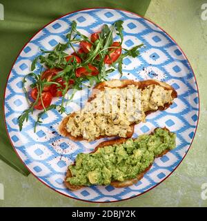 Croissant, Ei, Avocado, Rucola, Kirsche, Trüffel. Frühstücksangebot. Stockfoto