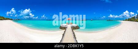 BlueOrange studio: Liegestühle und ein orangener Sonnenschirm an einem  schönen tropischen Strand auf den Malediven