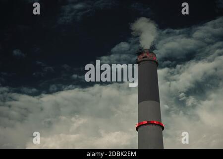 Rauch, der aus dem Kamin des Kraftwerks Reading an einem dunklen Himmel austritt. Es befindet sich in Tel Aviv, Israel. Konzept der Industrie, Verschmutzung, Elektrizität, Stockfoto