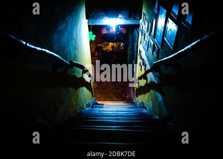 Dramatische Sicht auf die unheimlich Treppen von oben in die Dunkelheit des Inneren des alten Pubs Stockfoto