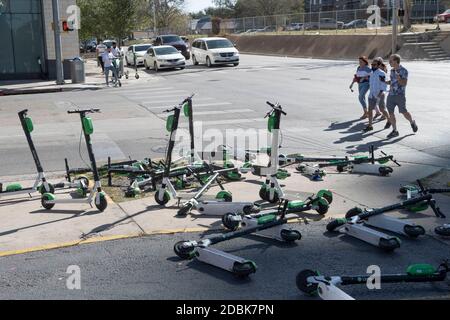 Scooters Würgen die Ecken von East Cesar Chavez und Red River Street an einem Sonntagmorgen in der Innenstadt von Austin, TX. Die beliebte Art, Austin's Stadtkern zu erkunden, hat eine Reihe von urbane Gefahren hervorgebracht, nachdem viele Besucher sie nach einer Partynacht in den Unterhaltungsvierteln Rainey und Sixth Street auf Gehwege werfen. Stockfoto