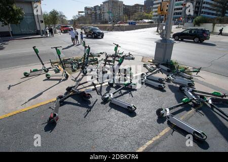 Scooters Würgen die Ecken von East Cesar Chavez und Red River Street an einem Sonntagmorgen in der Innenstadt von Austin, TX. Die beliebte Art, Austin's Stadtkern zu erkunden, hat eine Reihe von urbane Gefahren hervorgebracht, nachdem viele Besucher sie nach einer Partynacht in den Unterhaltungsvierteln Rainey und Sixth Street auf Gehwege werfen. Stockfoto