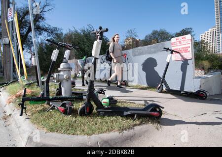 Scooters Würgen die Ecken von East Cesar Chavez und Red River Street an einem Sonntagmorgen in der Innenstadt von Austin, TX. Die beliebte Art, Austin's Stadtkern zu erkunden, hat eine Reihe von urbane Gefahren hervorgebracht, nachdem viele Besucher sie nach einer Partynacht in den Unterhaltungsvierteln Rainey und Sixth Street auf Gehwege werfen. Stockfoto