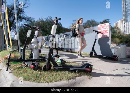 Scooters Würgen die Ecken von East Cesar Chavez und Red River Street an einem Sonntagmorgen in der Innenstadt von Austin, TX. Die beliebte Art, Austin's Stadtkern zu erkunden, hat eine Reihe von urbane Gefahren hervorgebracht, nachdem viele Besucher sie nach einer Partynacht in den Unterhaltungsvierteln Rainey und Sixth Street auf Gehwege werfen. Stockfoto