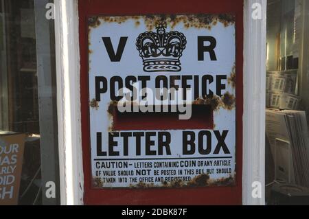 Der alte Briefkasten aus der Regierungszeit von Königin Viktoria wurde in die Wand des Dorfladens und Postamtes im Dorf Glynde in East Sussex eingelassen Stockfoto