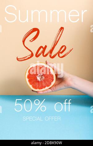 Beschnittene Ansicht der Frau hält saftige Hälfte der Grapefruit in der Nähe Sommer Verkauf, fünfzig Prozent Rabatt, Sonderangebot Schriftzug auf beige und blau Stockfoto