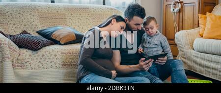 Familie mit Kind und schwangere Mutter tablet Stockfoto