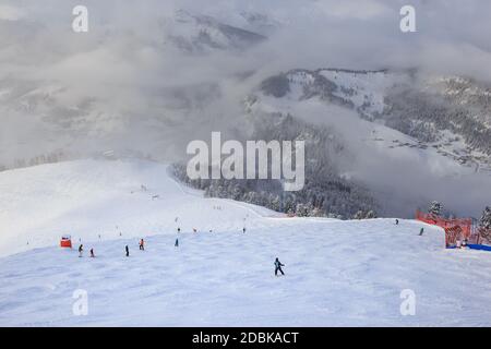 Skifahrer gehen eine Skipiste mit Blick auf die Berge, Dolomiten, Italien Stockfoto