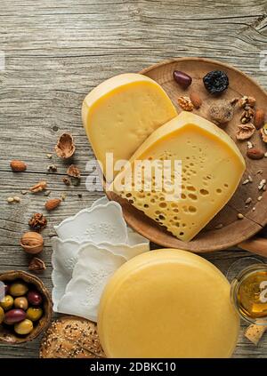 Auswahl an Käse, Wein, Nüssen und Früchten auf einem Holztisch. Draufsicht. Freier Speicherplatz für Text. Stockfoto