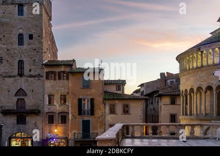 Arezzo, Toskana, Italien - Dezember 2019: Die Kirche Santa Maria della Pieve, befindet sich am Abend auf dem Hauptplatz des historischen Zentrums von Arezzo. Weihnachtslicht auf den mittelalterlichen Gebäuden Stockfoto