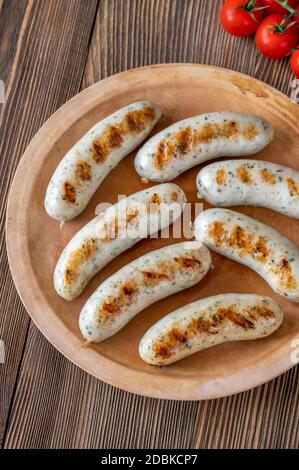 Gegrillte Würstchen mit einem Bündel Kirschtomaten auf dem Teller Stockfoto