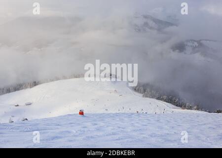 Skifahrer gehen eine Skipiste mit Blick auf die Berge, Dolomiten, Italien Stockfoto