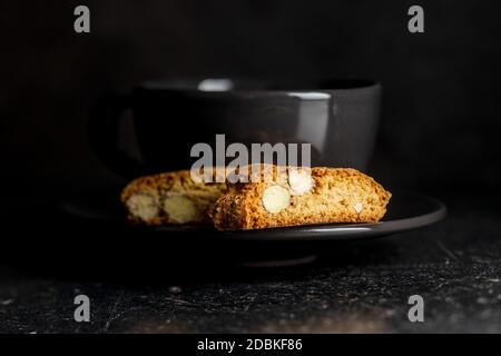 Süße italienische Cantuccini-Kekse. Mandeln Kekse auf schwarzem Teller. Stockfoto