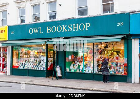 Eine Frau durchstösst das Fenster des Owl Bookshop in Kentish, öffnet nur für Klick und sammelt in der zweiten Coronavirus Pandemie Lockdown, London, UK Stockfoto