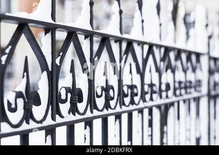 Geschmiedeter schwarzer Zaun mit Schnee bedeckt. Architektur von St.Petersburg im Winter. Russland Stockfoto