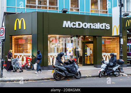 Lieferfahrer auf Motorrädern vor dem McDonald's Restaurant, das während der zweiten Sperre des Coronavirus-Pandemievirus zum Mitnehmen geöffnet ist, Kentish Town, London Stockfoto