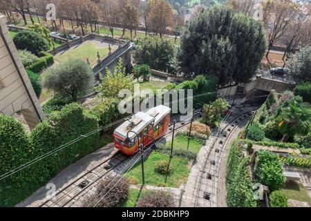 Obere Zeile in Bergamo Stadt Standseilbahn (funicolare Citta Alta). Rote Standseilbahn verbindet alte Obere Stadt und neu. Malerische Aussicht auf das historische Zentrum von Bergamo. Stockfoto