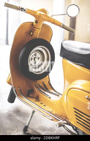 Vespa Roller mit gelber Farbe. Vespa ist eine italienische Marke von Roller von Piaggio hergestellt. Der legendäre Motorroller im italienischen Design. Foto im Retro-Stil. Stockfoto