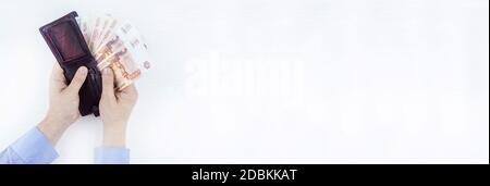 Den Beutel mit dem Geld in der Hand auf einem weißen Hintergrund Stockfoto