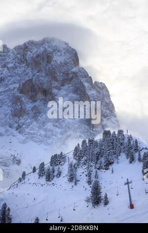 Teilansicht des Langkofels und Skilift im Winter, mit einigen Wolken dahinter, Gröden, Italien Stockfoto