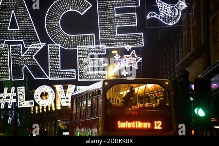 Brighton Sussex UK 17. November 2020 - Busse mit Passagieren an Bord passieren unter den Weihnachtslichtern in North Street , Brighton Hinzufügen von etwas Glanz zu den Coronavirus COVID-19 Sperrbeschränkungen in England : Credit Simon Dack / Alamy Live News Stockfoto